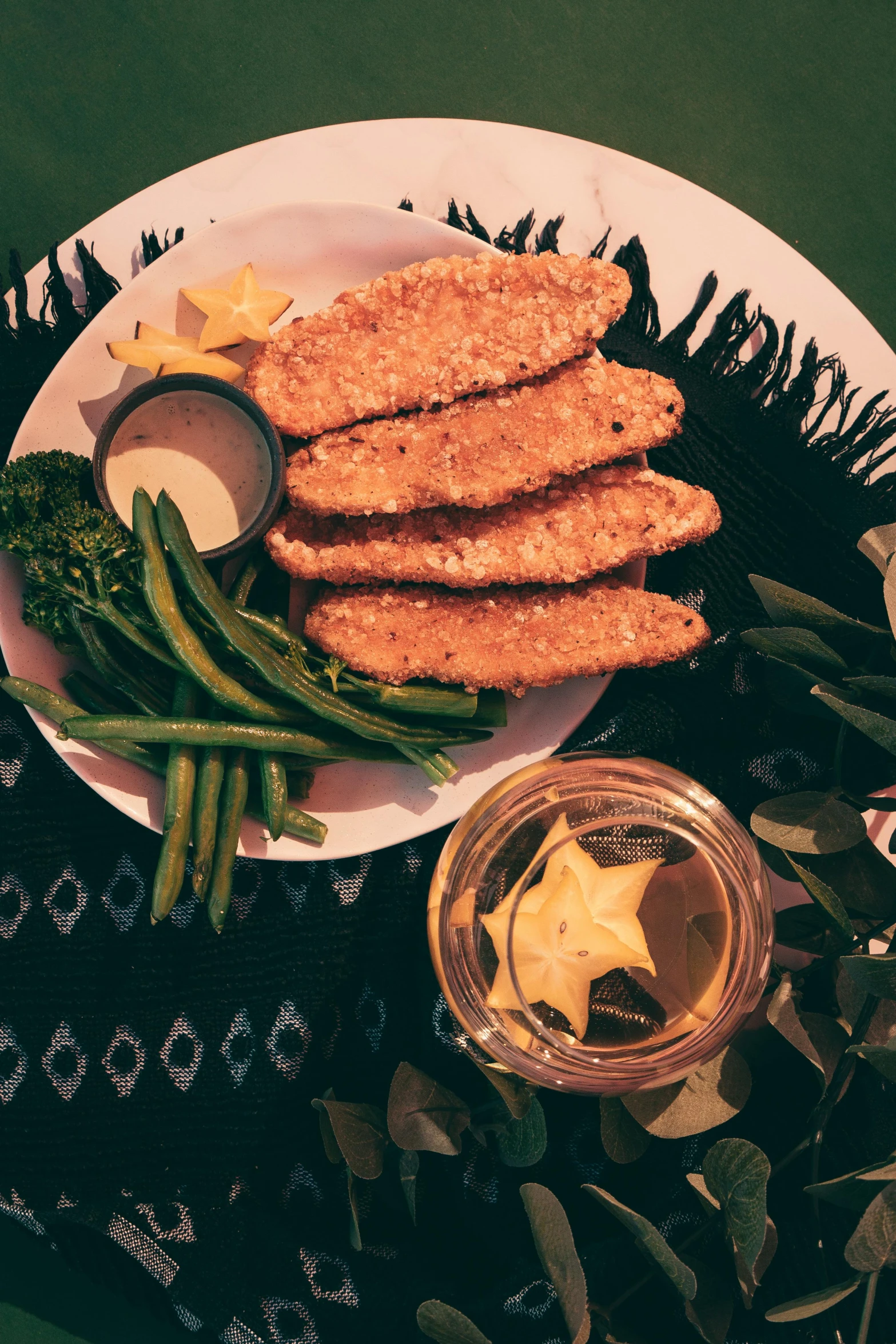 food on a plate, including broccoli, a jar of mustard and a cup with some star cutouts