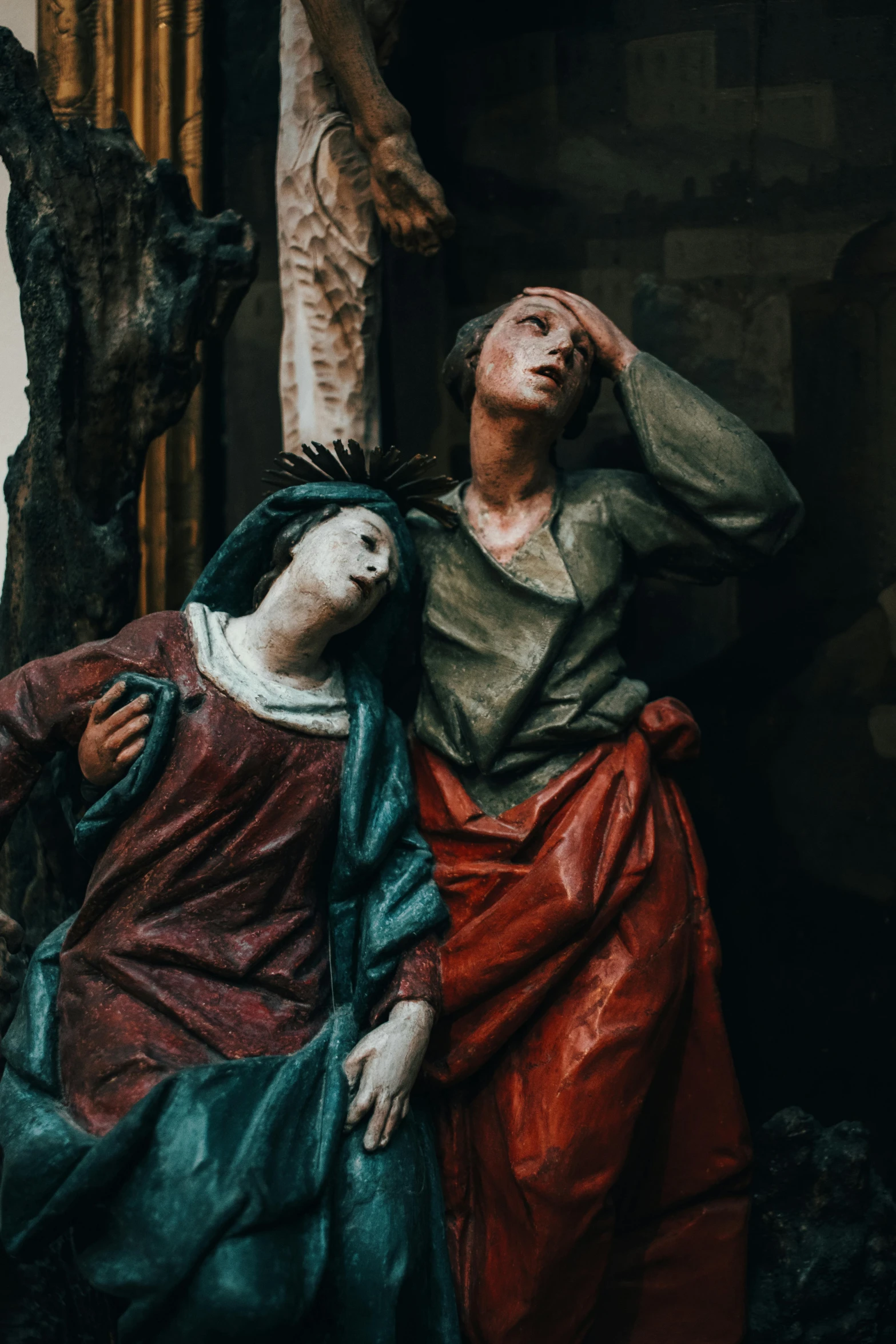 two statues of jesus with one lying on the other's side