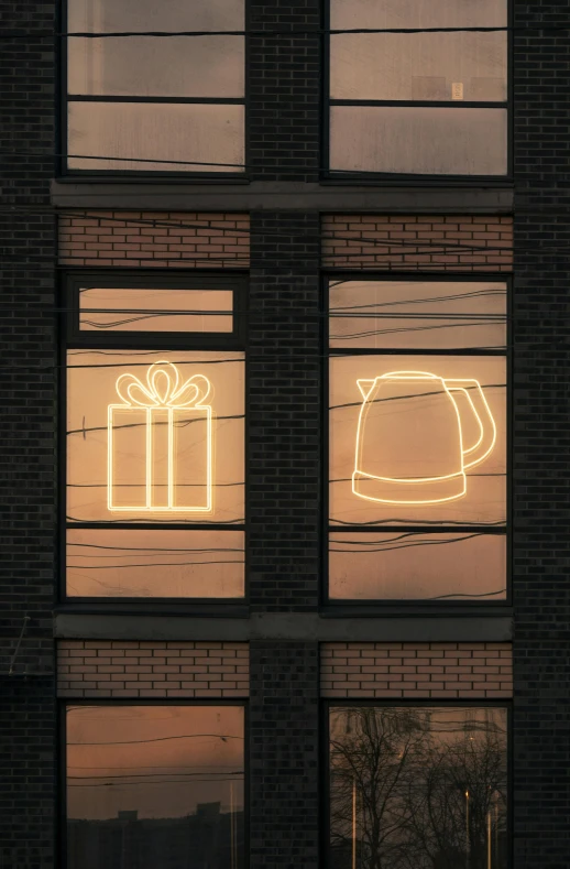 a lighted tea kettle next to boxes on a window