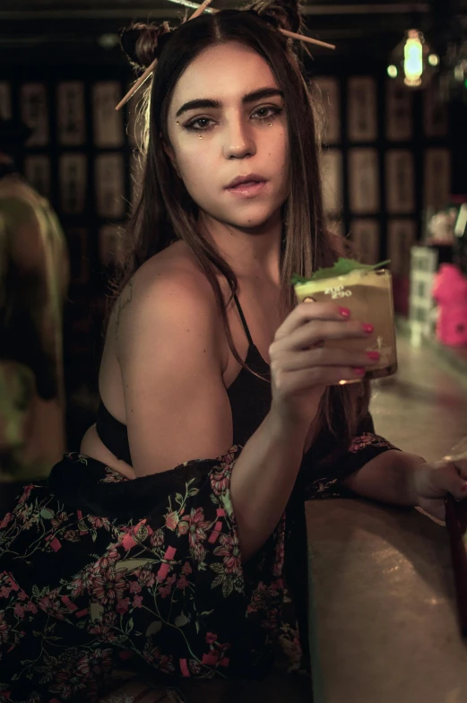 a woman is at a bar and holding a beverage