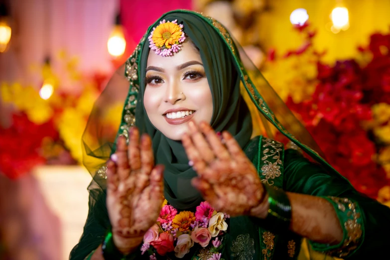 a woman wearing a headscarf holding her hands up in front of her