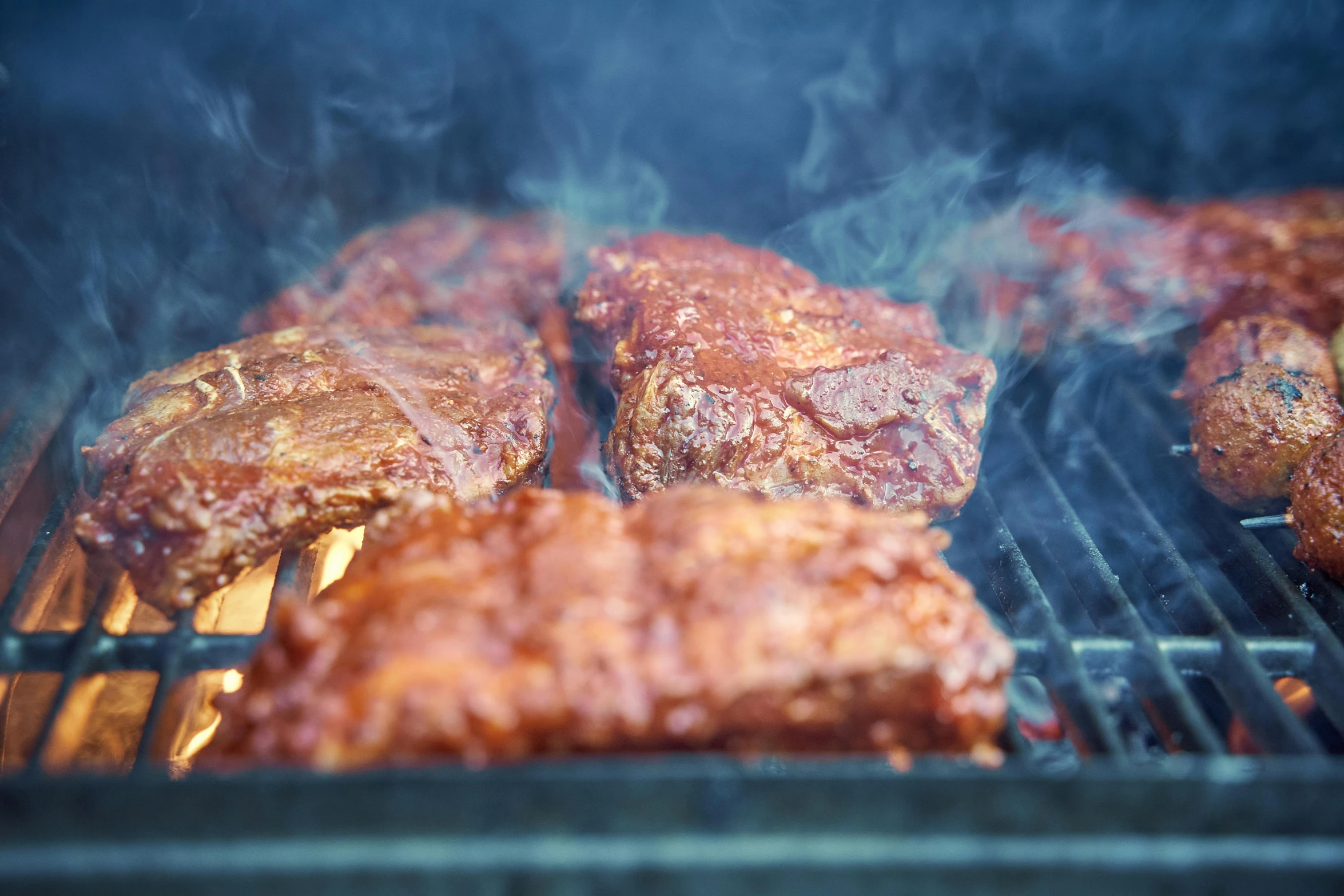 a meat grill being cooked by someone cooking