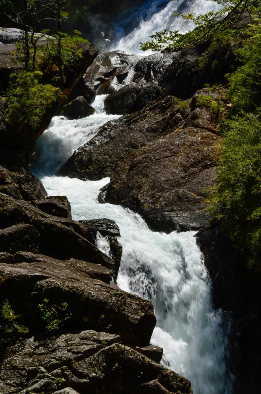 the water is coming down the large rocky cliffs