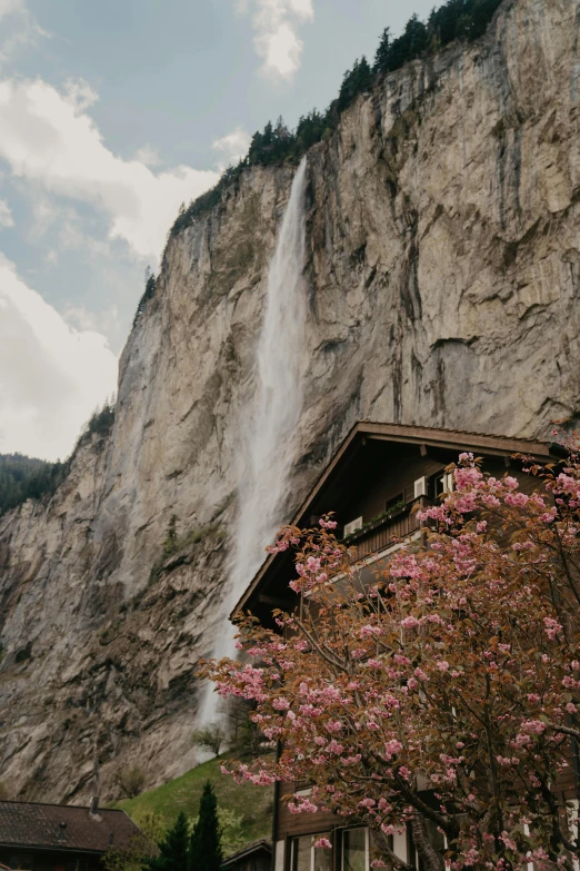 waterfall falling down from mountain on cloudy day