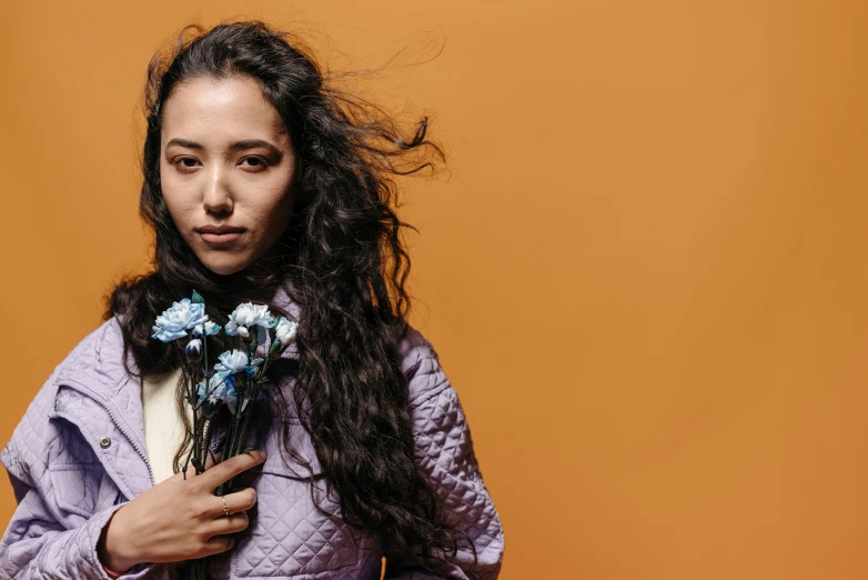 a woman with long hair holding flowers and a wind blown bouquet