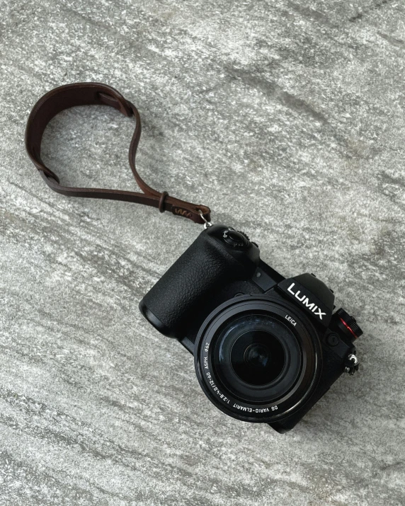 a camera sits on the beach with a strap