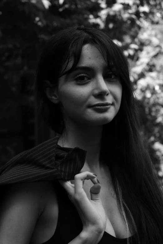 a beautiful young lady standing in front of trees