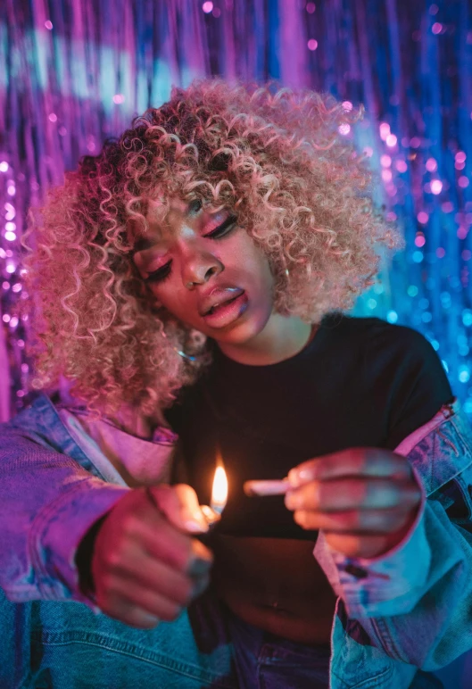 a woman with blonde hair holding a lit match