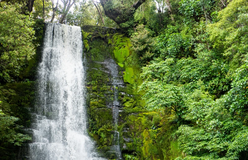 water falling from the top of a large waterfall