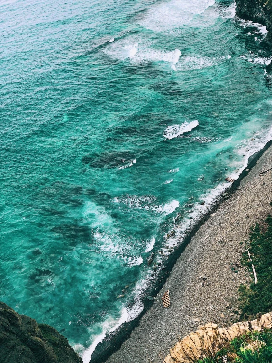 some big waves and small boats near the ocean