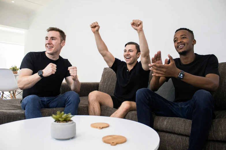 three men sitting on couches in the middle of a room