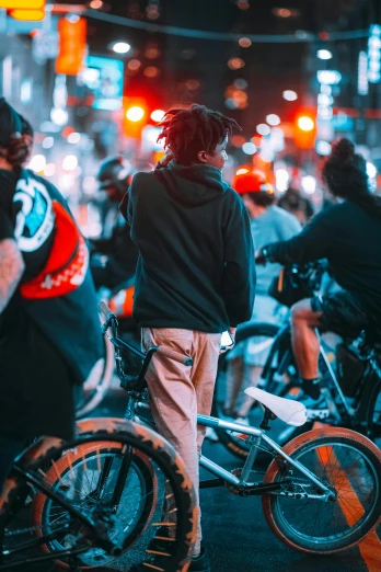 people standing on sidewalk with bikes in street