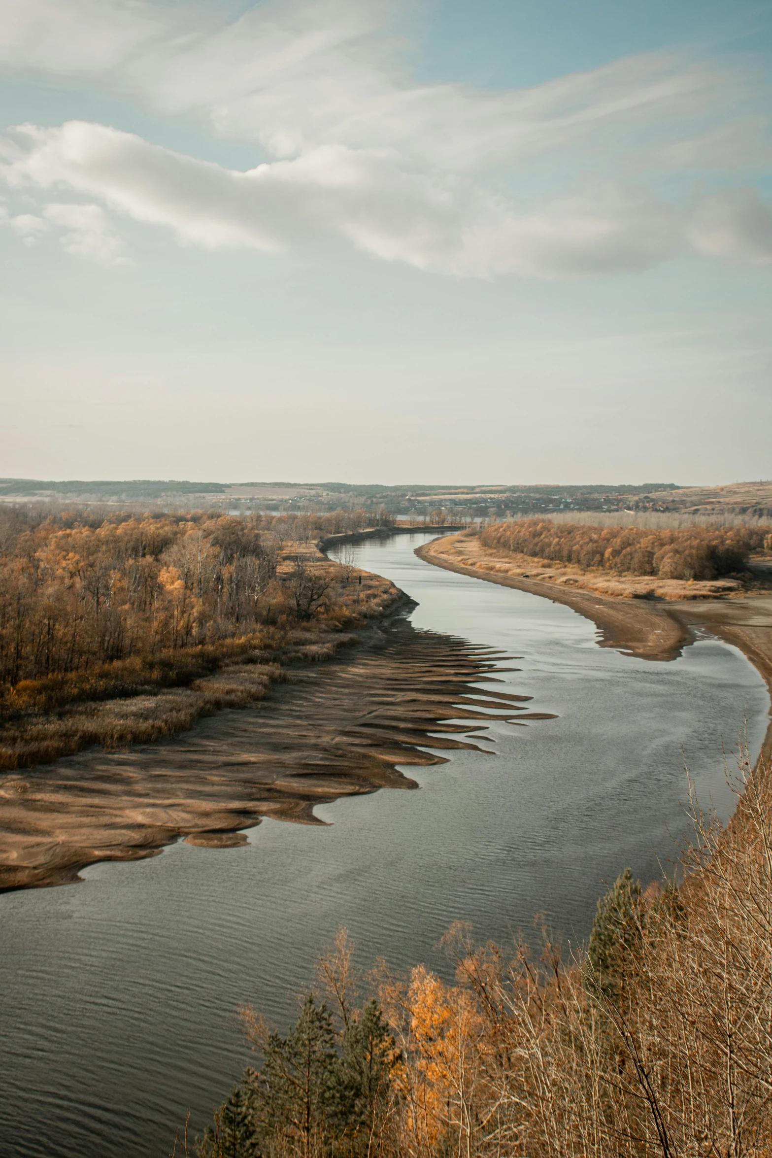 a scenic view of water near a tree filled area