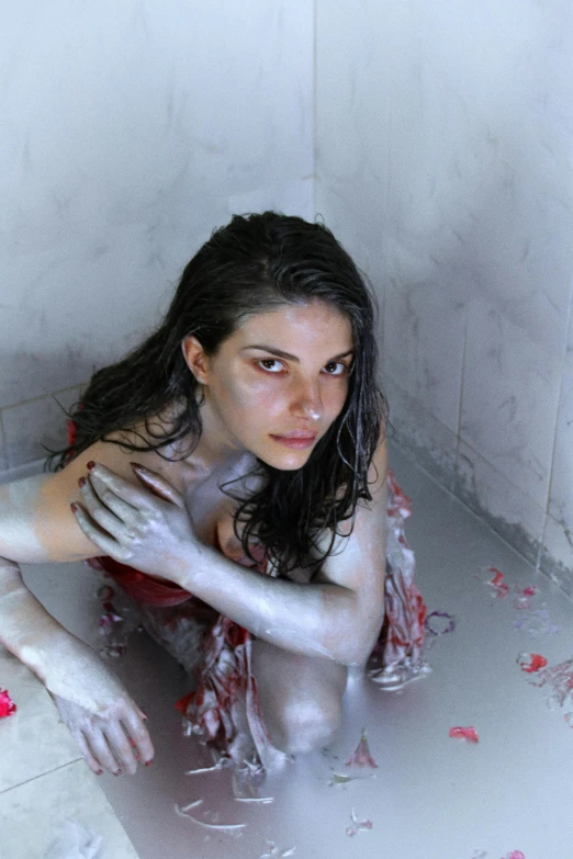 woman laying down in a bath tub with water coming from it