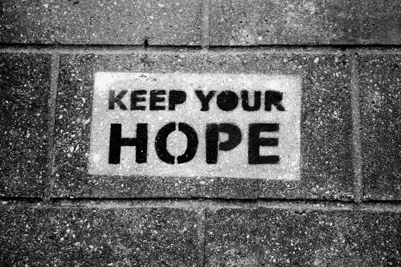 a keep your hope sticker on a building wall