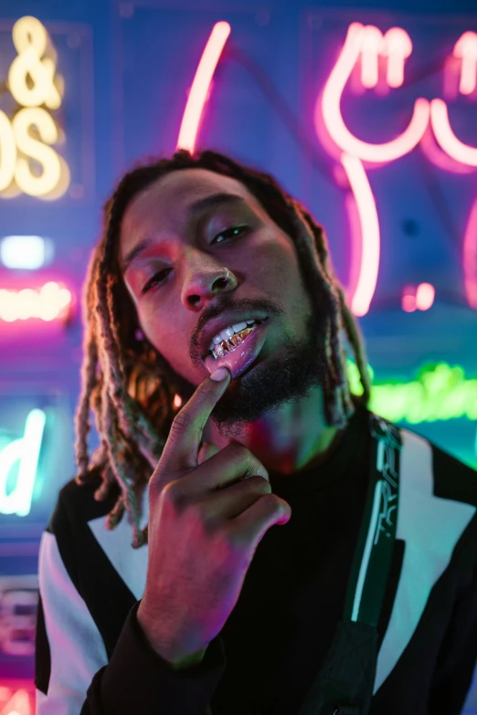 a person standing near many neon lights smoking a cigarette