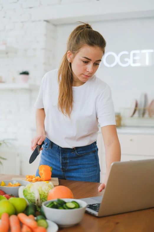 a woman is  up an orange in her kitchen