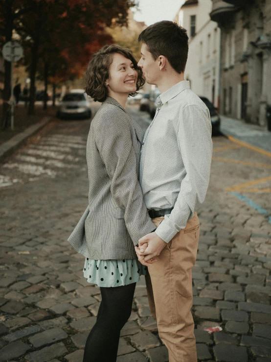 young couple standing together on a street corner