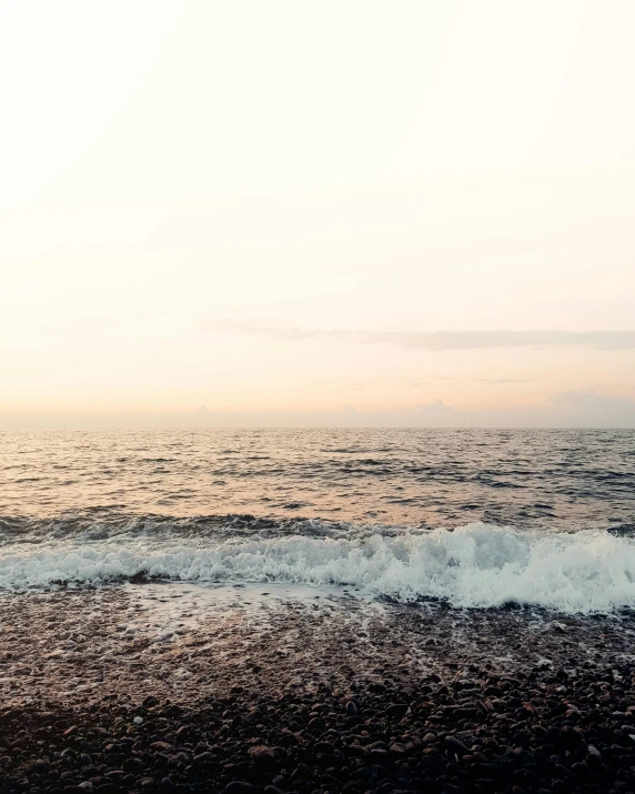 a man surfing on the waves at sunset