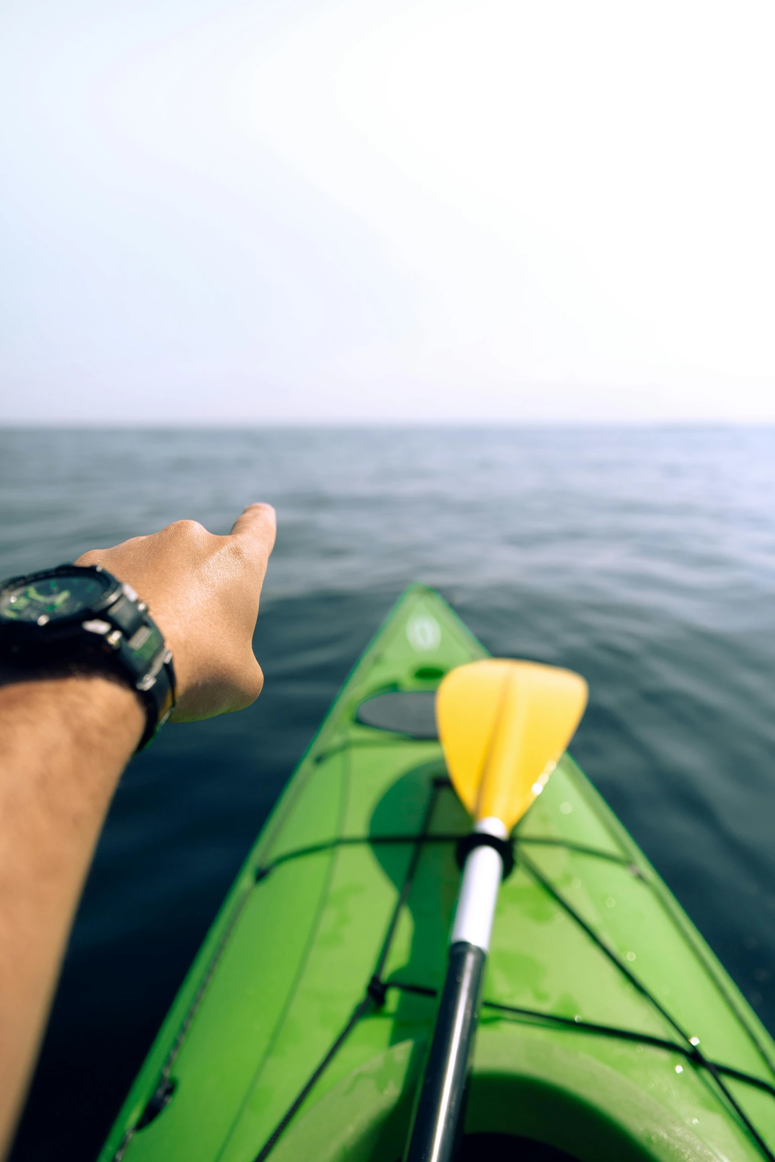 a person in the water rowing a green boat