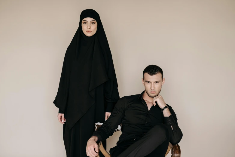 a man sitting next to a woman wearing a black outfit