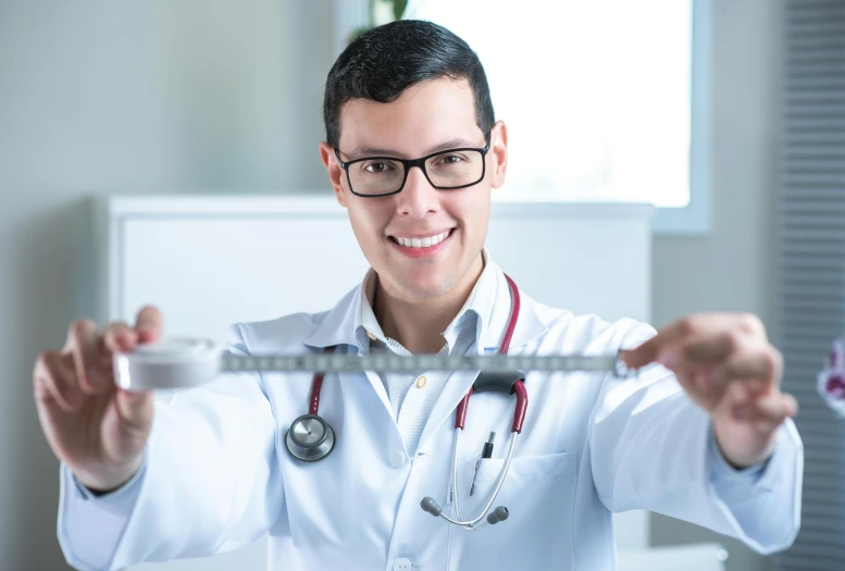 a male doctor is holding up his glasses
