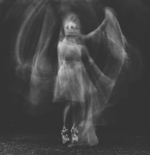 a black and white po of a woman's dress blowing in the wind