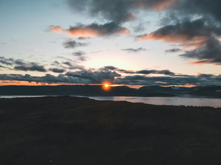 a view from the mountain at sunset with clouds