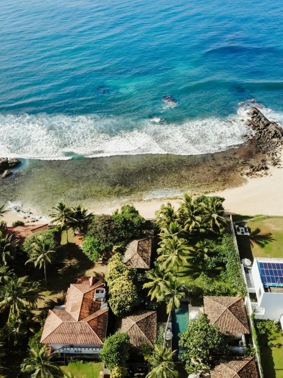 the beach area is next to the houses with many trees around