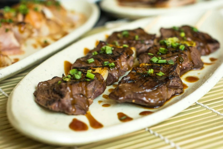 the food on the plate has sauce and green onions