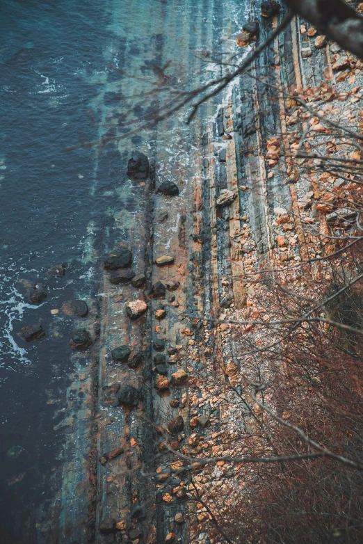 a bird flies over an area of water and rocks