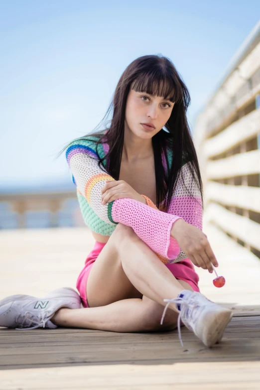 a beautiful woman sitting on the ground in short shorts