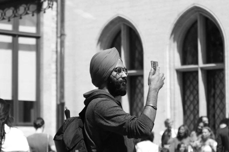 man taking selfie with a cell phone during a busy day