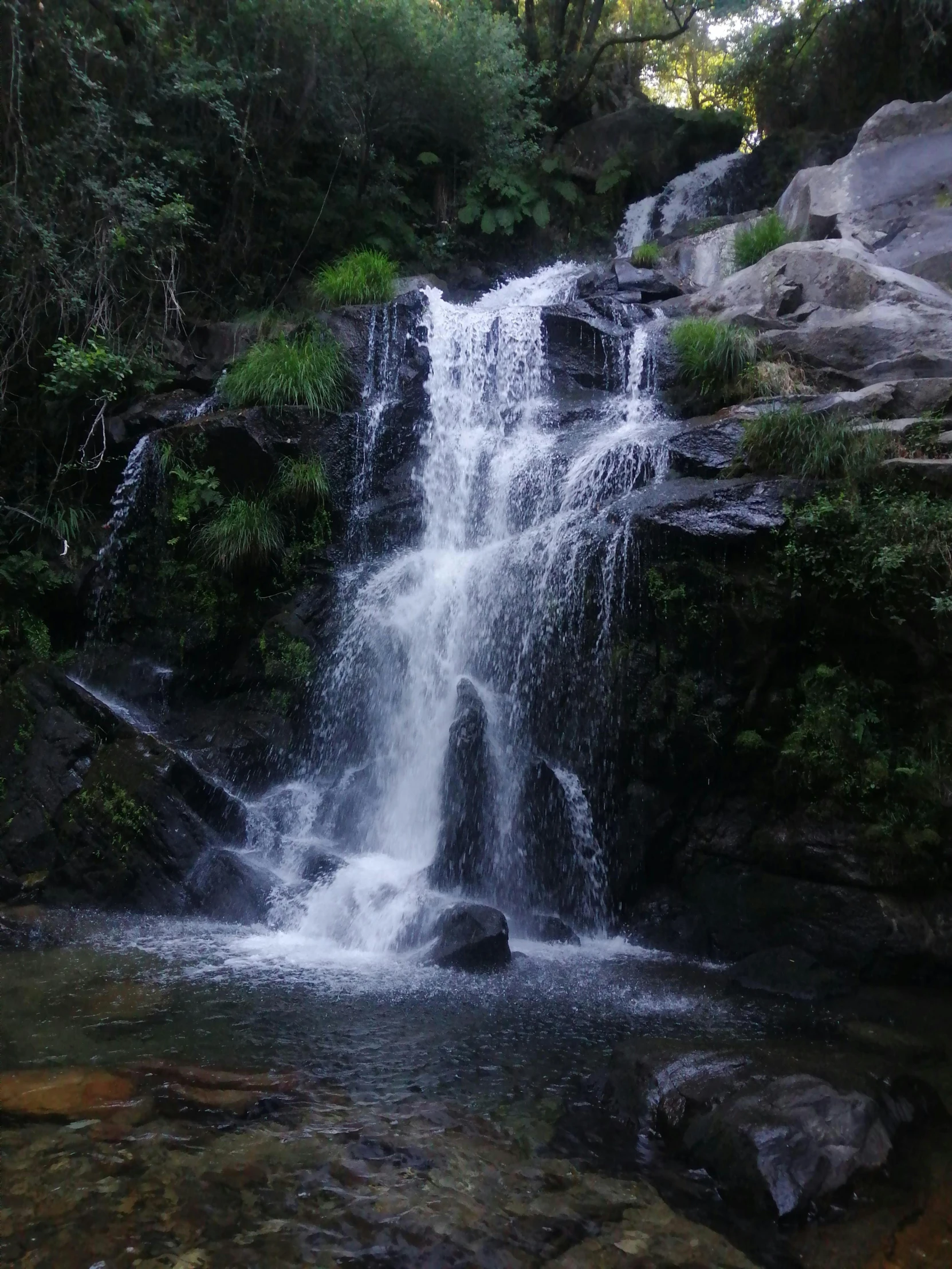 a very tall waterfall is shown in the wild