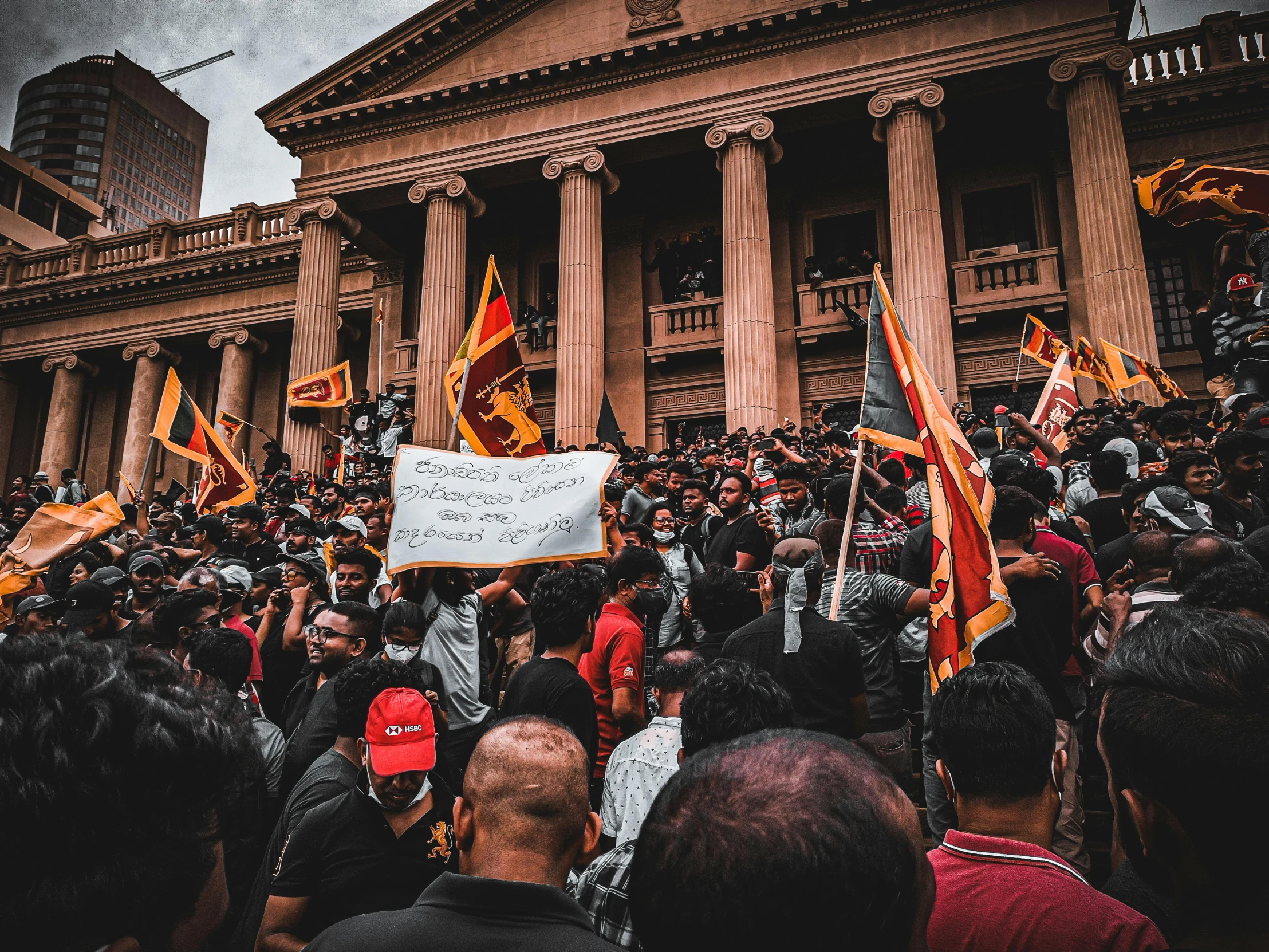 many people with signs stand in front of a building