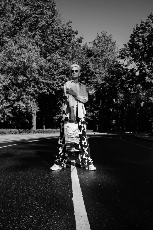 a man stands in the middle of the road next to a motorcycle