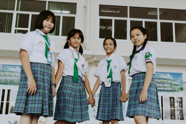 four s wearing school uniforms standing next to each other