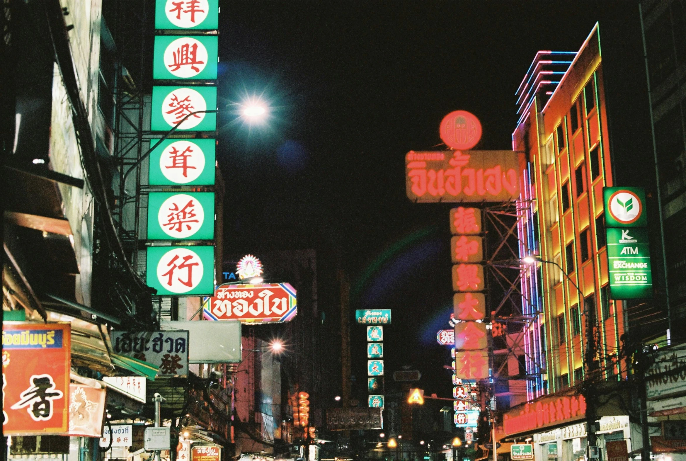 a city street filled with tall colorful signs and traffic