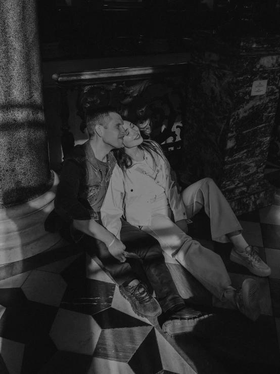 a couple kissing on the floor while holding hands