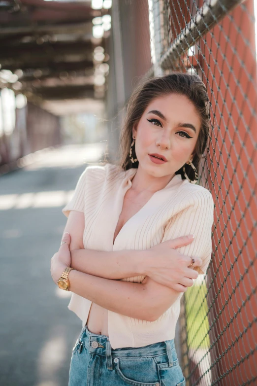 a beautiful young lady leaning against a fence