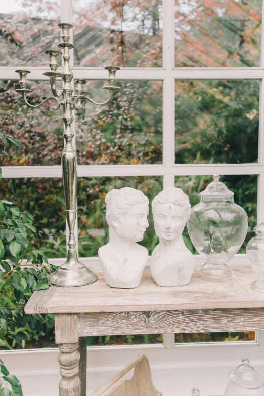 three vases on a window sill near a candela