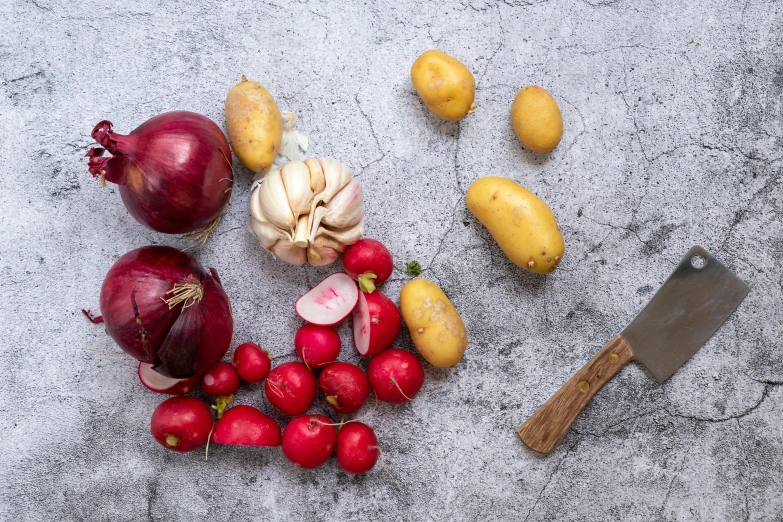 several fresh vegetables sit on a concrete surface