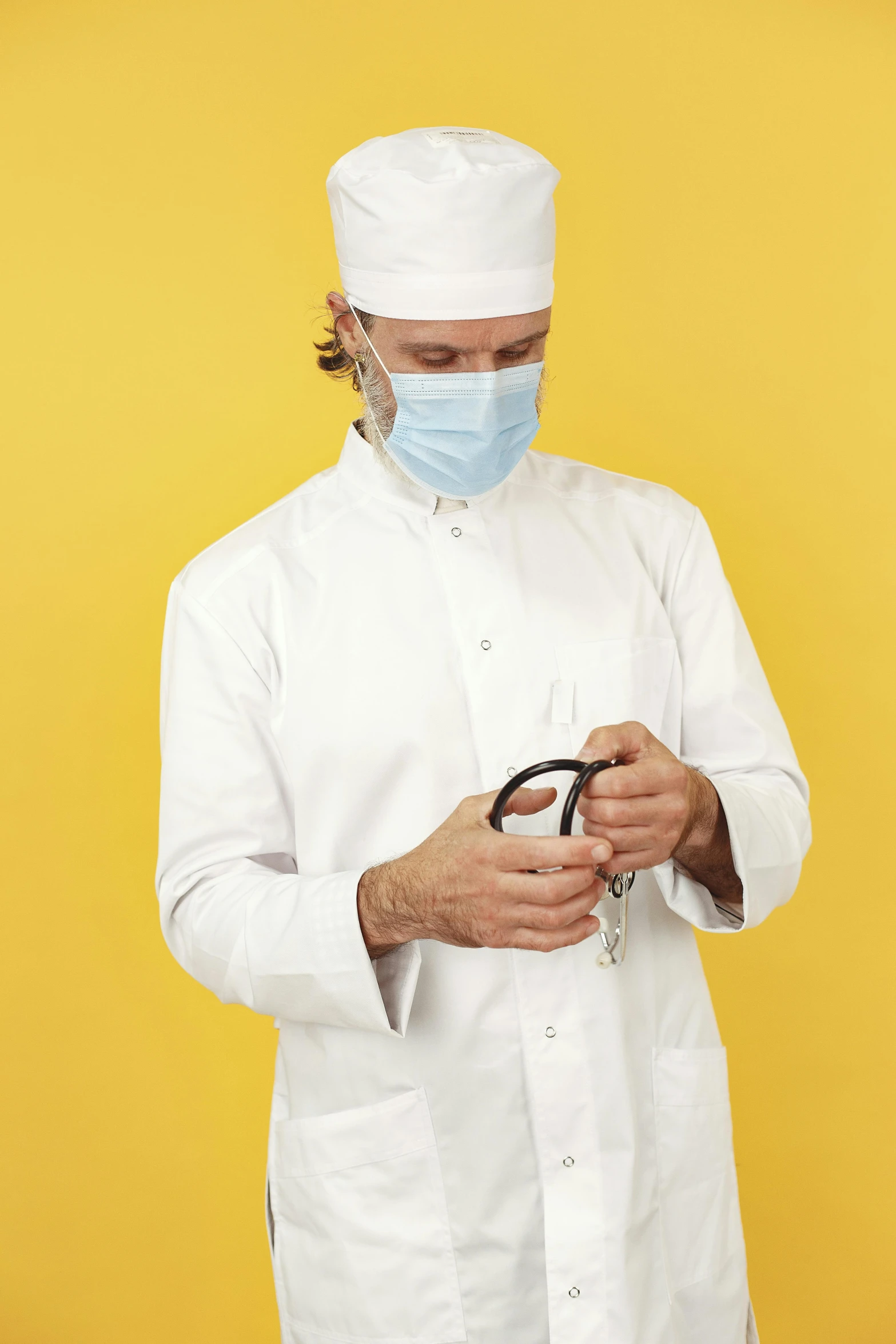 a man with a surgical mask is holding a pair of scissors