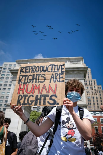 a man holding a sign reading radioactive fights are human rights