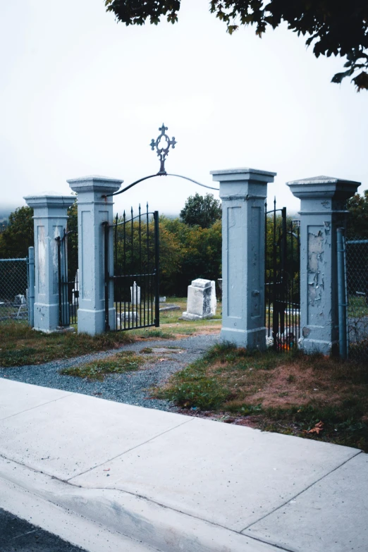 a gate in front of a graveyard with crosses