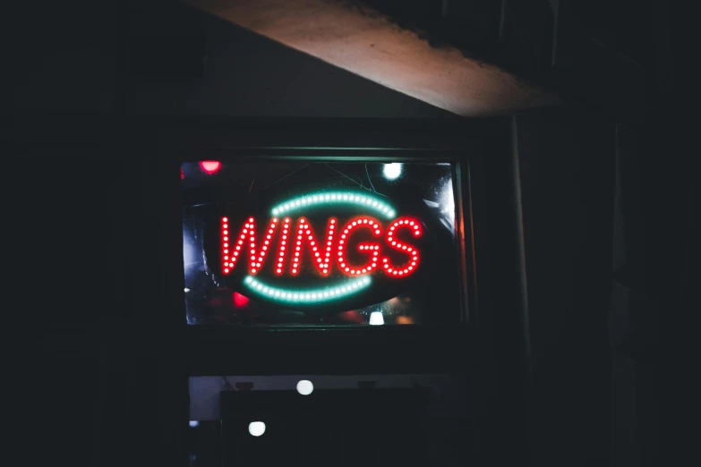 a lighted sign advertising win's hangs in a dark room