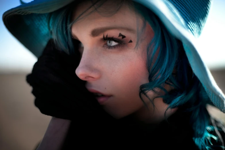 a woman wearing a hat and blue hair