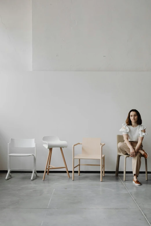 a girl sits in a chair by a table