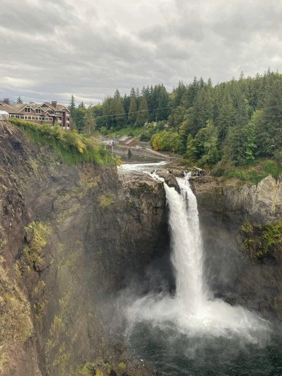 an aerial view of a waterfall with a small building in the background