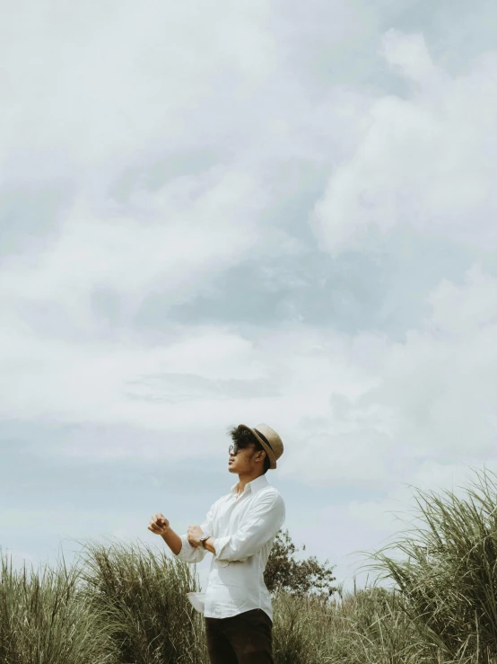 a person that is flying a kite by some grass